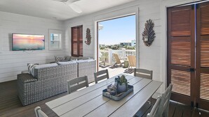 Un intérieur moderne avec un canapé, une table à manger et une vue à travers une porte.