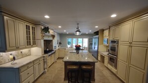 A spacious kitchen with a central island, built-in appliances, and ample cabinetry.