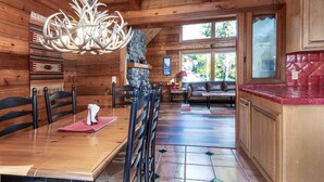 Un interior de madera con comedor, cocina y una pared de piedra.
