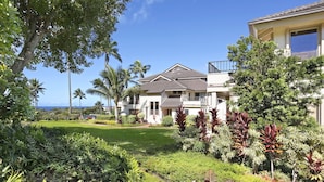 A two-story house with a well-maintained garden, a balcony, and a view of the ocean. - Kahala 822 By Parrish Kauai - AC and 1 level (Koloa)