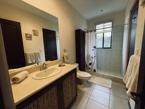 Een bad/douchecombinatie, handdoeken