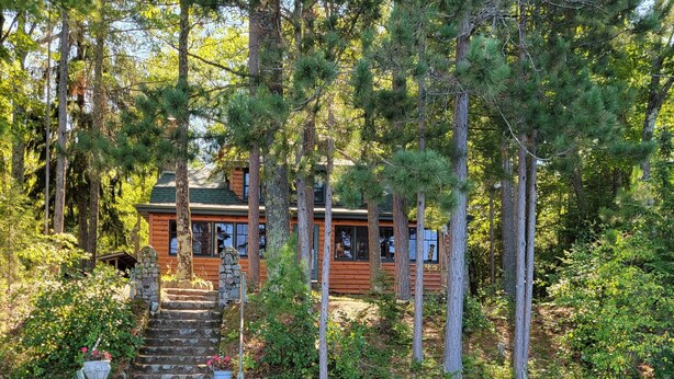 A cabin with a dock and a small pond. - Classic Northwoods Cabin Experience Awaits You (Lac du Flambeau)