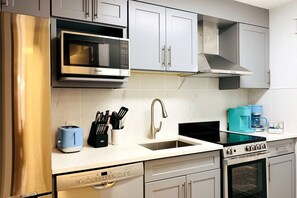 A modern kitchen with stainless steel appliances, a dishwasher, and a coffee maker.
