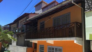 En toetages bygning med balkon og et lille vindue i stueetagen.