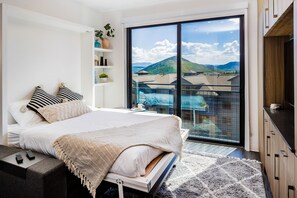 Relax in this serene bedroom with a large bed, mountain views, and a balcony.