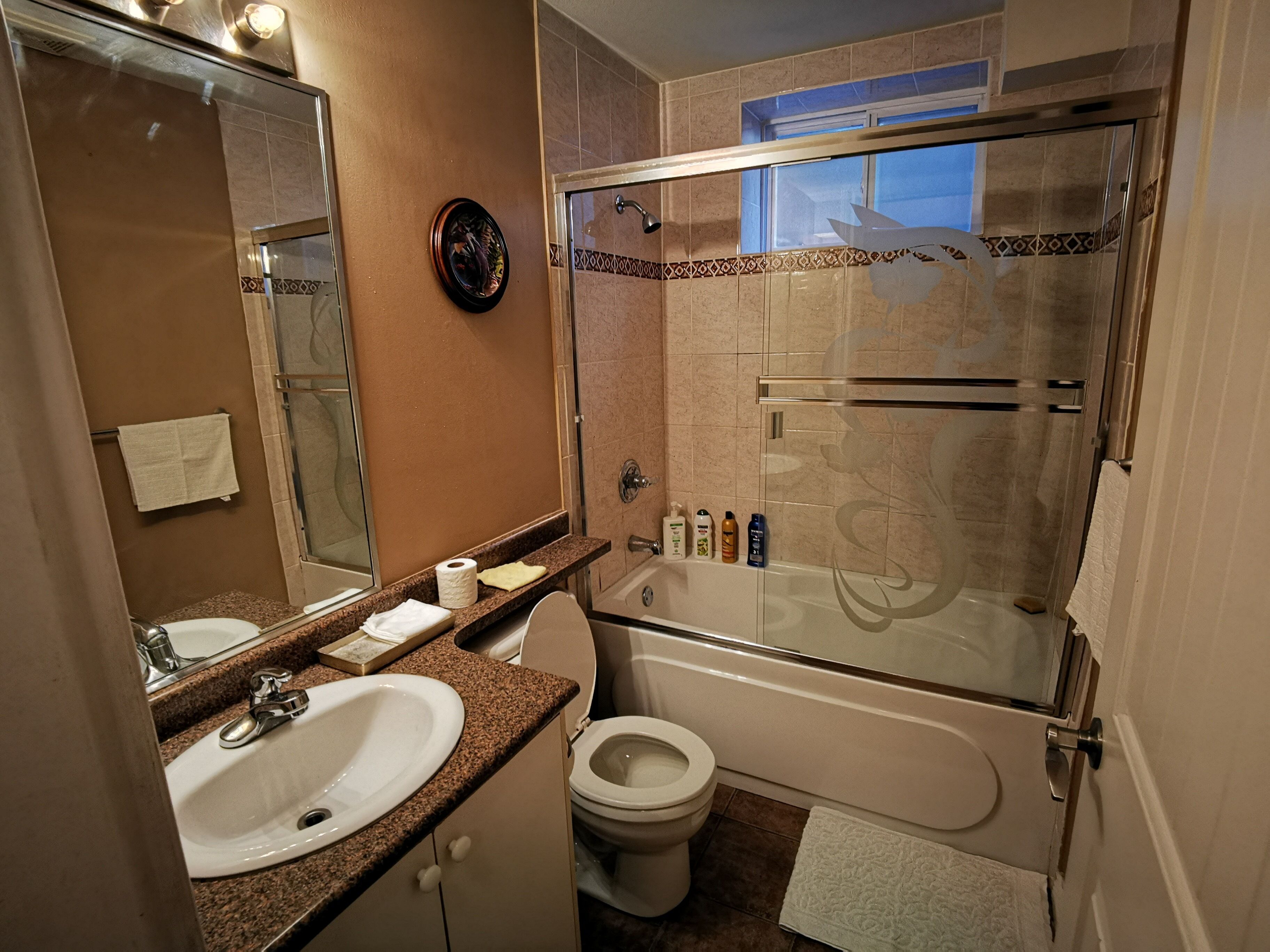 A bathroom with a sink, toilet, and shower.