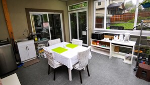 A kitchen with a dining table, chairs, a microwave, and a coffee maker.