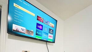 A flat-screen TV mounted on a wall displaying a streaming service interface.