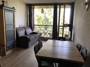 Ein Zimmer mit einem Holzespeisetisch, einer dunkelbraunen Ledersofa und einem Holzschrank.