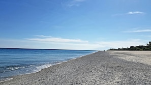 A pebbled beach with a clear sky and calm sea. - "Valle Arangea" Apartment (Condofuri Marina)
