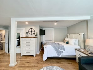Cozy retreat with a neatly made bed, bedside table, and wall-mounted TV.