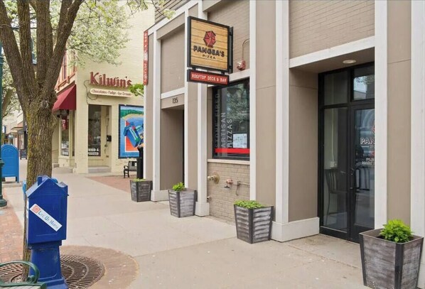 A storefront with signs for 'Kilwin's' and 'Panera's Pizza'. - 2BR Corner Unit I Balcony + Trail Access + Bikes (Traverse City)