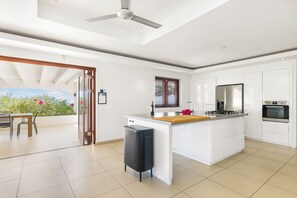 A modern kitchen with a central island, built-in appliances, and a view to an outdoor area.