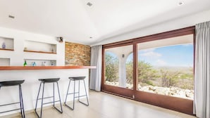 A modern kitchen with a bar area, large windows, and a view of the desert landscape.
