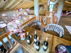 Ein Holztisch mit vier Weinflaschen und einer Blumenvase.