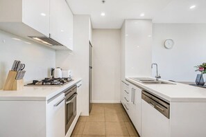 Equipped with a gas stove, oven, and dishwasher, this kitchen offers a convenient cooking space.