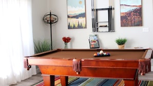 A pool table in a room with a striped carpet, a potted plant, and two paintings on the wall. - Private Home at the foot of Yosemite National Park (Mariposa)