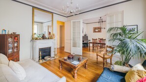 A spacious living room with a fireplace, wooden furniture, and a large mirror. - Large 1BR close to Bastille and Aligre (Paris)