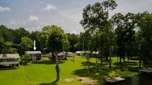 A lakeside property with multiple cabins, a dock, and a grassy area.