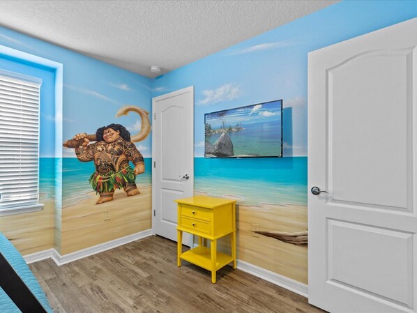 Relax in a beach-inspired retreat with a vibrant mural, comfortable seating, and a convenient TV.