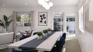 A modern dining area with a long table, blue chairs, and potted plants. - Pet & Kid-Friendly Beach Retreat Near Town  +EVC , Fire Pit , Beach & Baby Gear! (Santa Barbara)