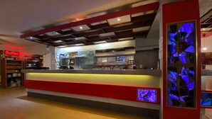 Eine moderne Hotelhalle mit einer Rezeption, einem Buffetbereich und einer dekorativen Glaswand.