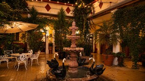 An indoor courtyard with a fountain, seating area, and potted plants. - Copa de Oro Hotel Boutique (Mascota)