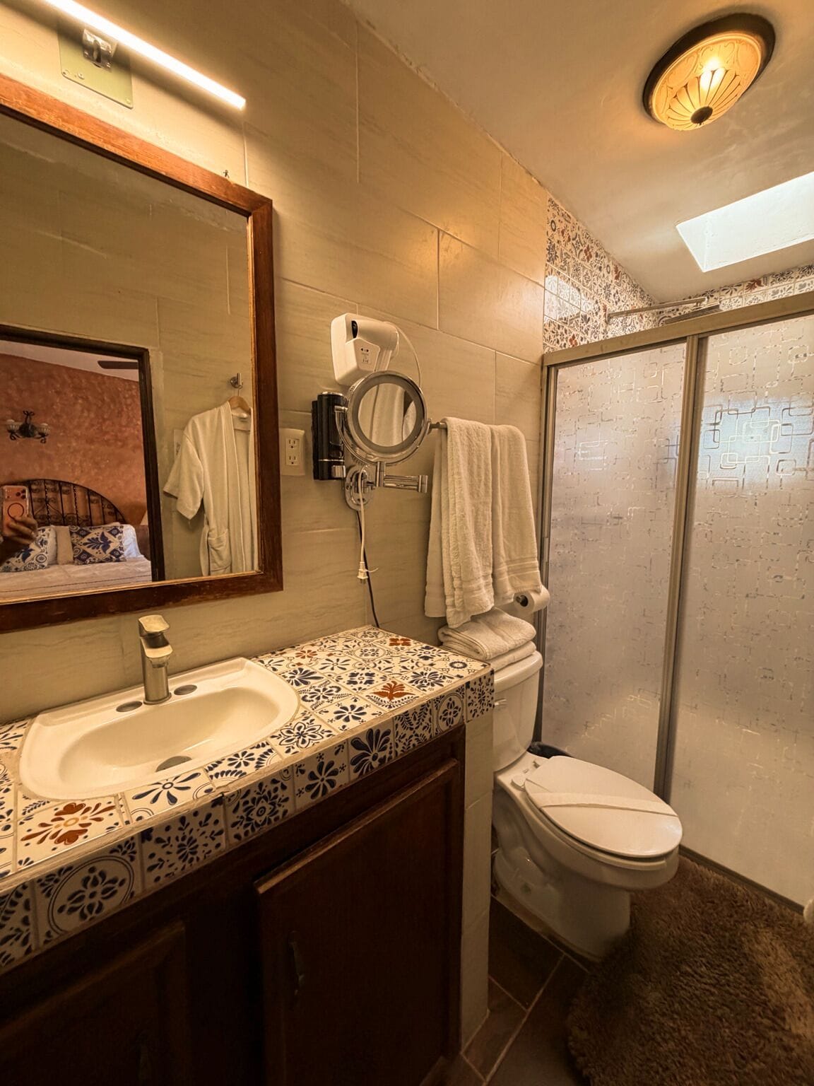 Un baño con lavabo, espejo, inodoro y ducha.