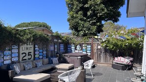 Eine Terrassengruppe mit einer Geschwindigkeitsbegrenzungstafel, einer Sofagarnitur und einem Grill.