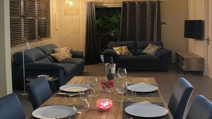 Ein Essbereich mit einem Holztisch, gedeckt für vier Personen, umgeben von blauen Stühlen.