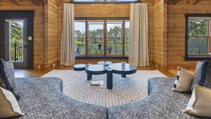 Ein Interieur einer Blockh ütte mit großem Fenster, einer Kandelaber und einem runden Tisch.