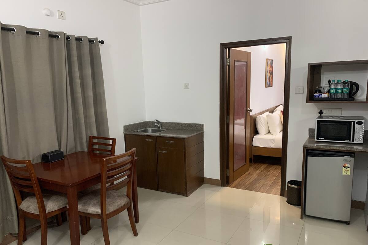 Um espaço compacto com cozinha compacta, área de jantar e quarto.