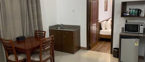 Un espacio habitable compacto con kitchenette, comedor y dormitorio.