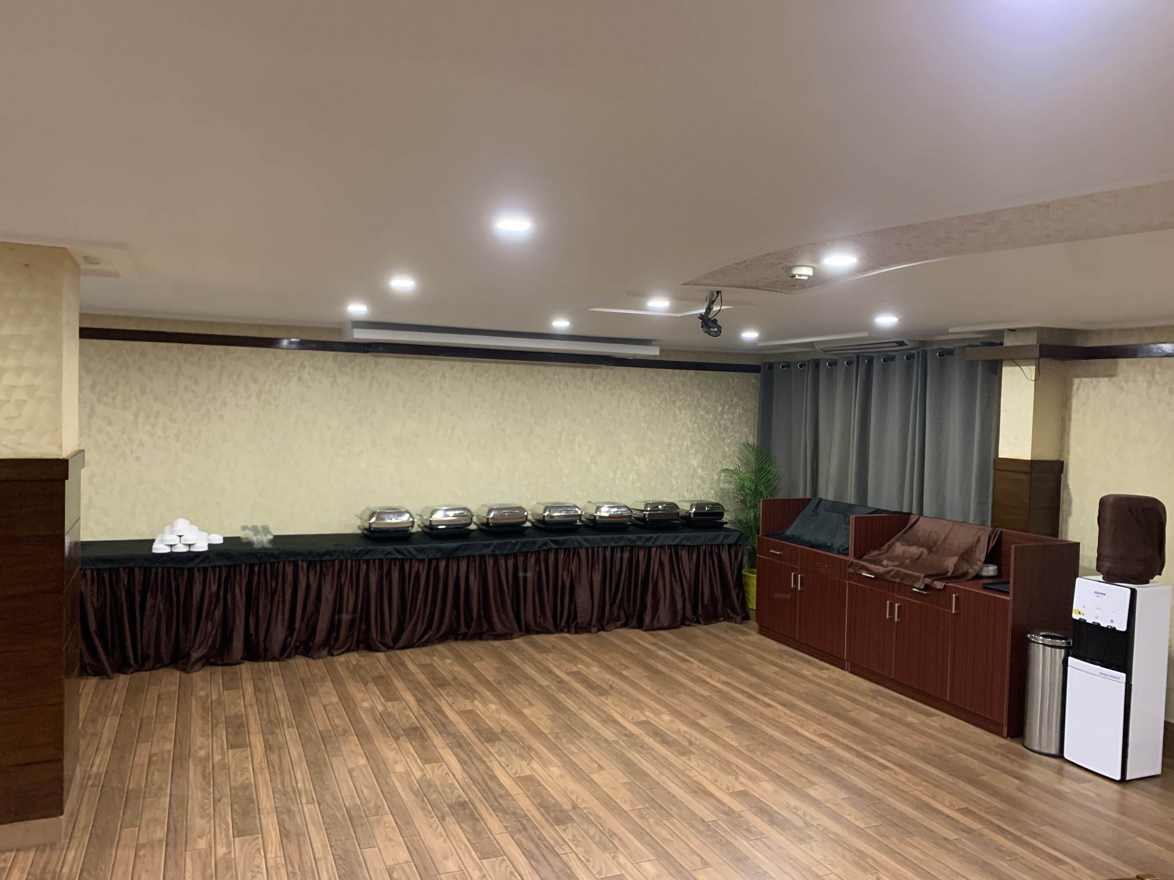 A conference room with a long table, a sofa, and a small kitchenette.