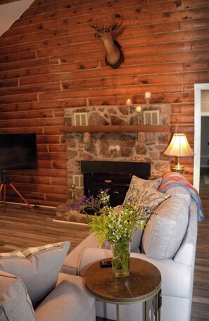 Cozy living room with a stone fireplace and comfortable seating area.