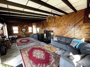 Relax in this inviting space with a comfortable sofa, wooden coffee table, and a potted plant.