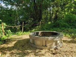 Surrounded by lush greenery, this fire pit offers a cozy gathering space.