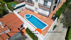 Une propriété résidentielle dotée d’une piscine, d’un toit en tuiles et d’un jardin.