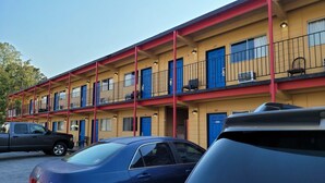 A motel with multiple floors, each with blue doors and balconies. - Relax inn (Lucedale)