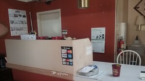 A reception desk with a bulletin board, a calendar, and a fire extinguisher. - Relax inn (Lucedale)