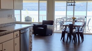 Een ruime keuken met een vaatwasser, een eethoek met een tafel en stoelen, en uitzicht op de omgeving.