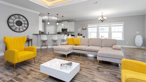Una sala de estar moderna con un sofá modular, sillones amarillos y una mesa de centro blanca.
