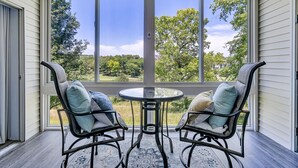 A room with two rocking chairs facing a large window overlooking a green landscape. - Enclosed Patio! Golf-Course View Near Branson Strip (Branson)
