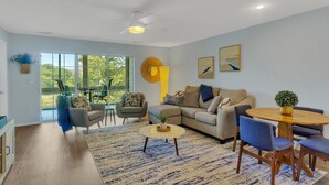 A modern living room with a sofa, chairs, a coffee table, and a dining table. - Enclosed Patio! Golf-Course View Near Branson Strip (Branson)