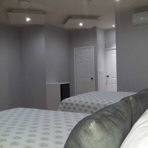 A bedroom with two beds, a wardrobe, and a door. - Hotel Pedregal (Nogales)