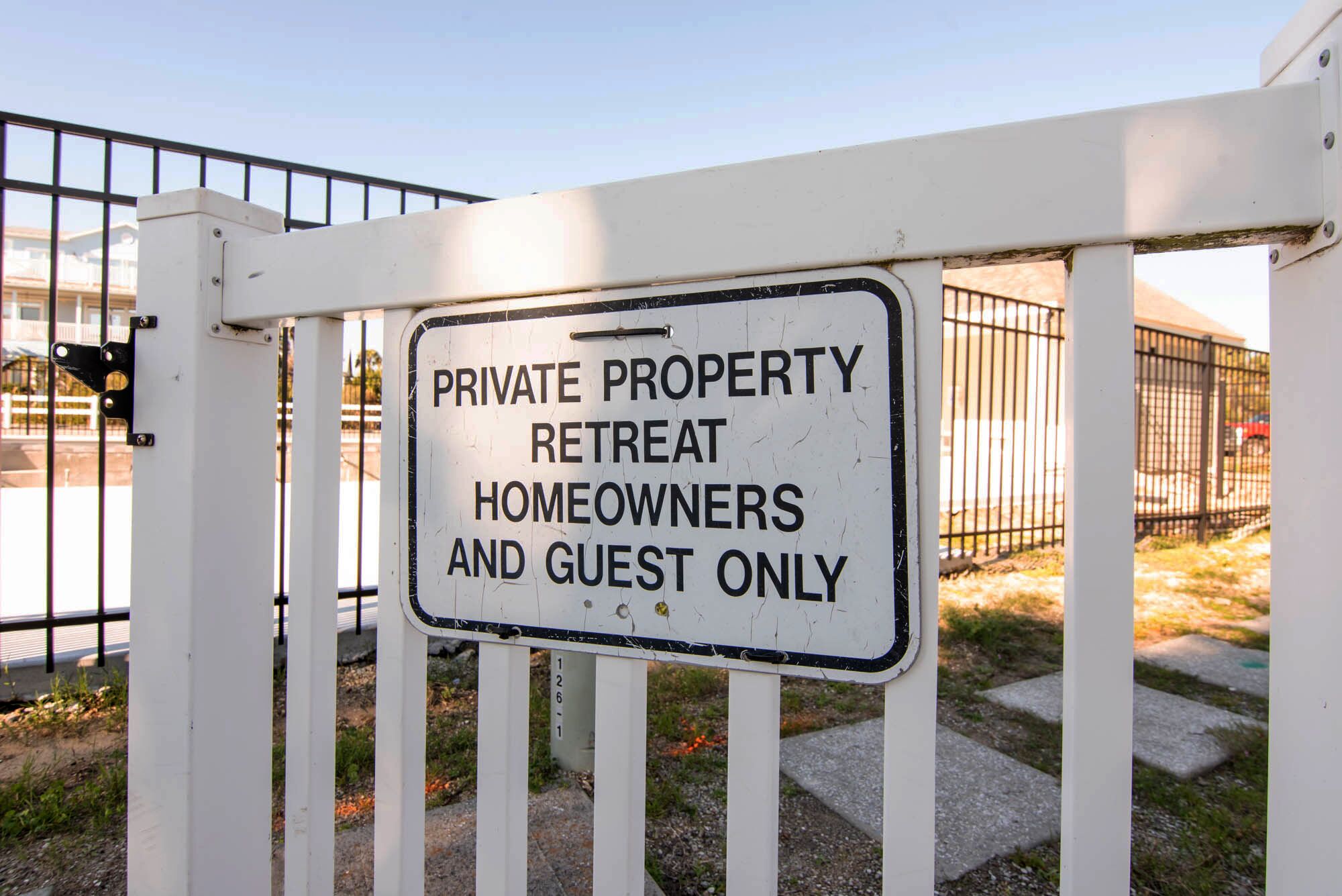 A sign on a gate that reads "PRIVATE PROPERTY RETREAT HOMEOWNERS AND GUEST ONLY."