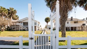 Una entrada cerrada a un área residencial con casas y una palmera.