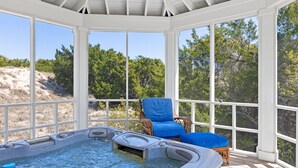 A hot tub area with a view of trees and a beach.