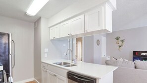 A modern kitchen with white cabinetry, a dishwasher, and a built-in oven. - Duet #103 xxxxxxxxxx (Austin)