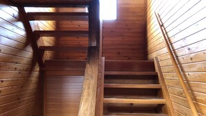 Un escalier en bois à l’intérieur d’une cabane en rondins.